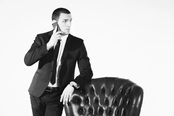 Businessman standing near leather chair — Stock Photo, Image