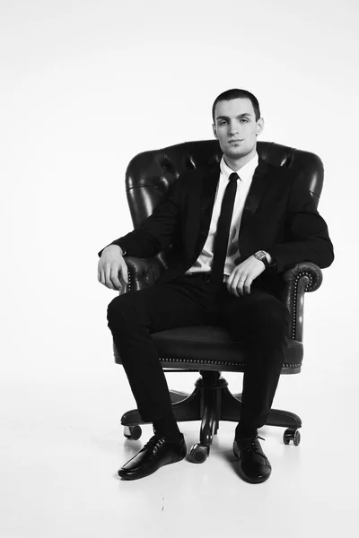 Empresário em pé perto de cadeira de couro — Fotografia de Stock