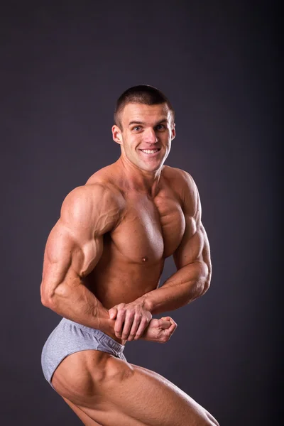 Bodybuilder shows his muscles — Stock Photo, Image