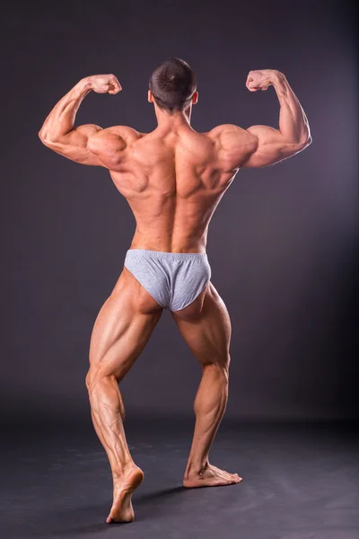 Bodybuilder shows his muscles — Stock Photo, Image