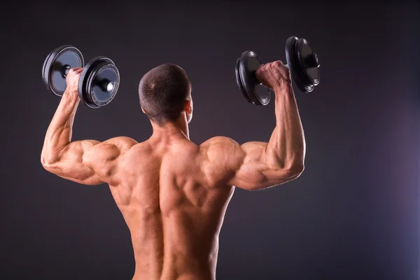 Deportista sosteniendo una mancuernas . — Foto de Stock