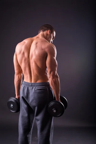 Deportista sosteniendo una mancuernas . — Foto de Stock