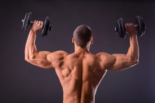 Deportista sosteniendo una mancuernas . — Foto de Stock