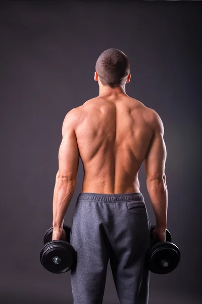 Deportista sosteniendo una mancuernas . — Foto de Stock