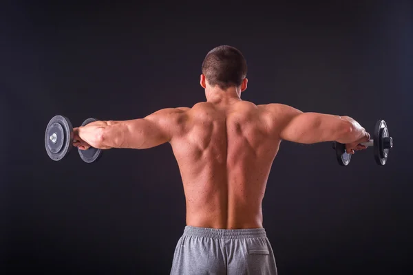 Deportista sosteniendo una mancuernas . — Foto de Stock