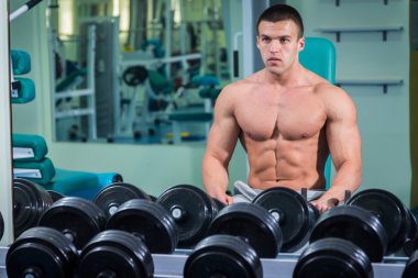 adam dumbbells ile bir spor salonu