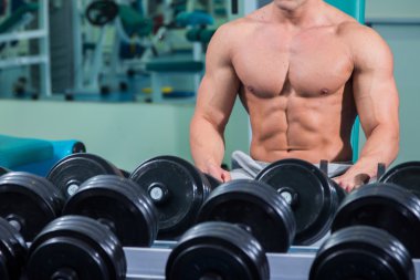 adam dumbbells ile bir spor salonu