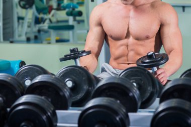 adam dumbbells ile bir spor salonu