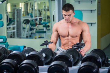 adam dumbbells ile bir spor salonu