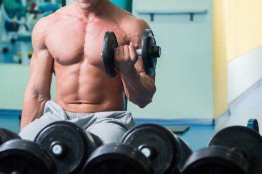 adam dumbbells ile bir spor salonu