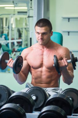 adam dumbbells ile bir spor salonu