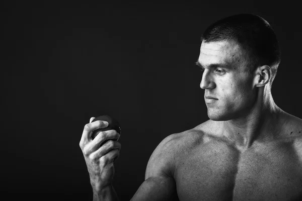 Muscular man holding apple — Stock Photo, Image