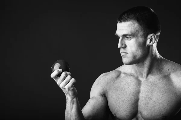 Hombre musculoso sosteniendo manzana — Foto de Stock