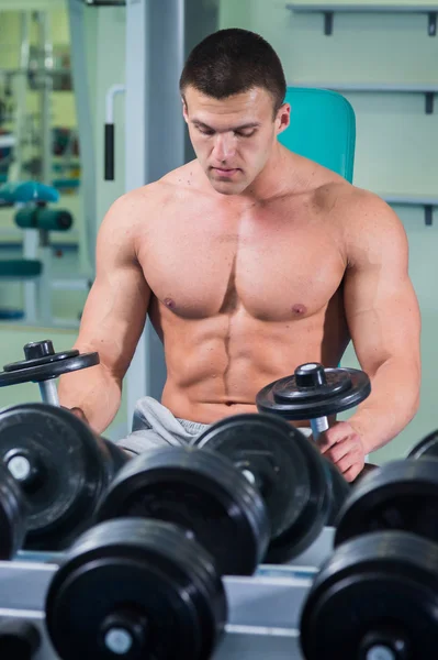 Homme dans une salle de gym avec haltères — Photo