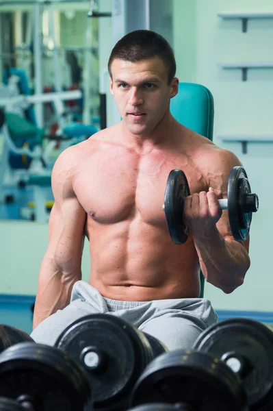 Uomo in palestra con manubri — Foto Stock