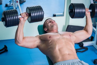 adam dumbbells ile bir spor salonu