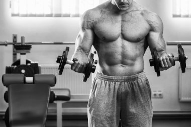 adam dumbbells ile bir spor salonu