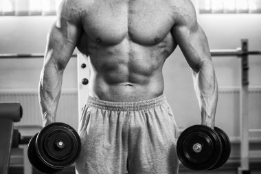 adam dumbbells ile bir spor salonu