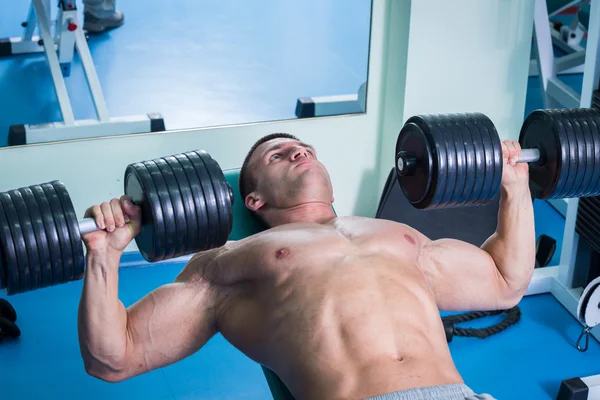 Adam dumbbells ile bir spor salonu — Stok fotoğraf