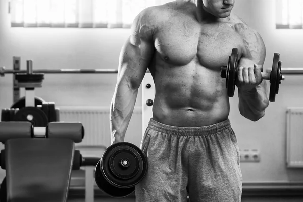 Homme dans une salle de gym avec haltères — Photo