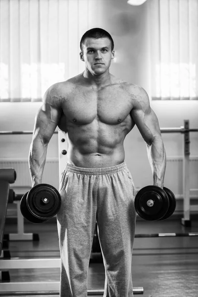 Man in a gym with dumbbells — Stock Photo, Image