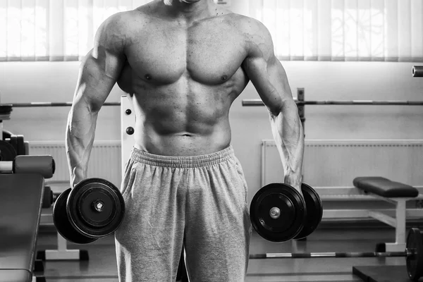 Man in a gym with dumbbells — Stock Photo, Image