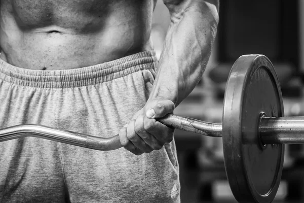 Man in een sportschool met halters — Stockfoto