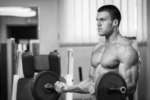 Homme dans une salle de gym avec haltères — Photo