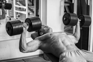 Vücut geliştirmeci dumbbells ile kuvvet eğitimi yapıyor