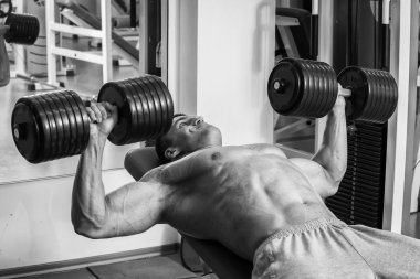 Vücut geliştirmeci dumbbells ile kuvvet eğitimi yapıyor