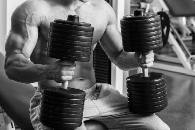 Vücut geliştirmeci dumbbells ile kuvvet eğitimi yapıyor