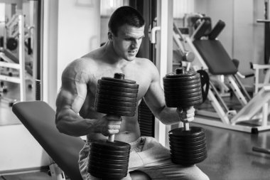 Vücut geliştirmeci dumbbells ile kuvvet eğitimi yapıyor