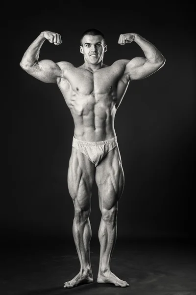 Bodybuilder shows his muscles — Stock Photo, Image