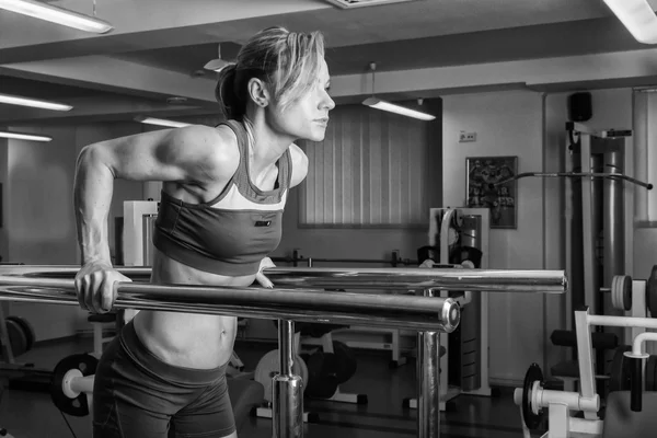 Blondin utbildar muskulös kropp i gymmet — Stockfoto