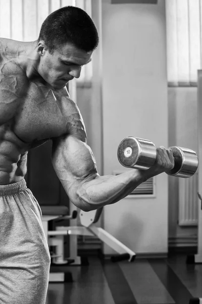 Bodybuilder trainiert die Muskeln der Arme. — Stockfoto