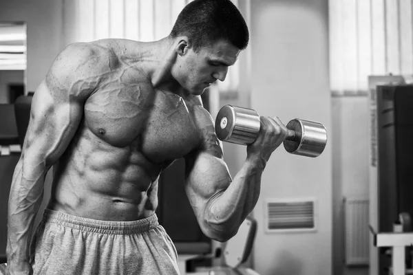 Bodybuilder trains the muscles of the arms. — Stock Photo, Image