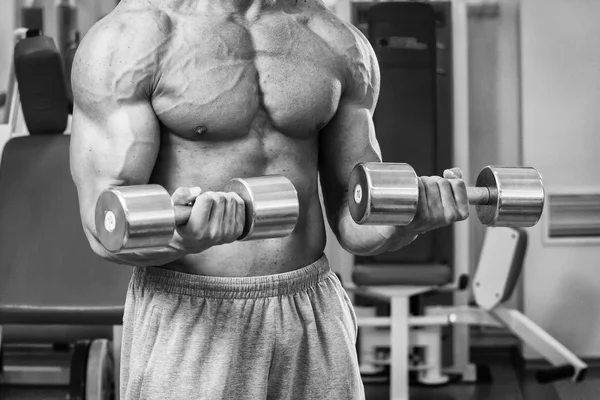 Bodybuilder trainiert die Muskeln der Arme. — Stockfoto