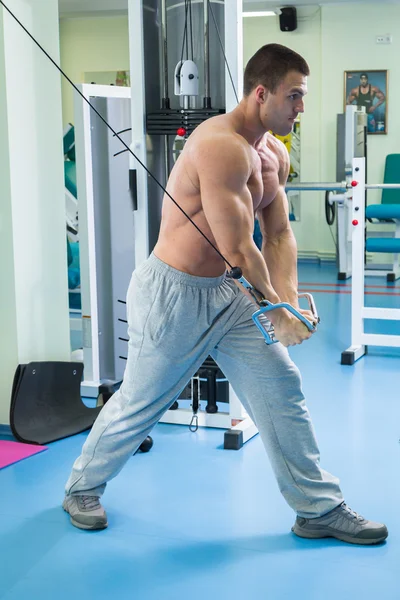 El hombre hace ejercicios en el gimnasio —  Fotos de Stock