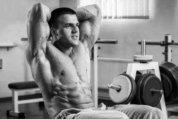 Bodybuilder pompage des muscles abdominaux dans la salle de gym — Photo