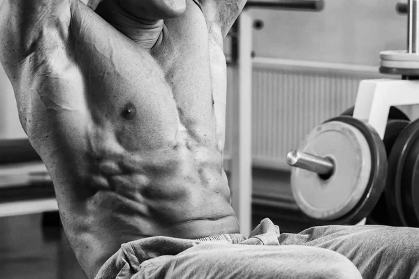 Bodybuilder pumping abdominal muscles in the gym — Stock Photo, Image