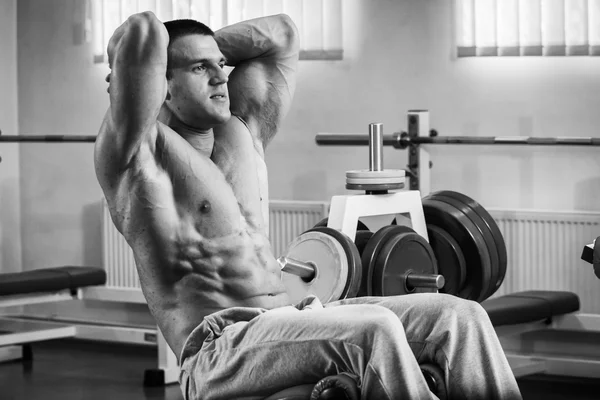 Bodybuilder pompage des muscles abdominaux dans la salle de gym — Photo