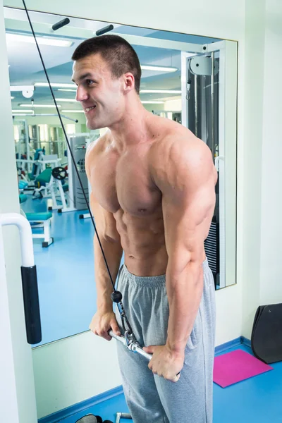 Man makes exercises at gym — Stock Photo, Image