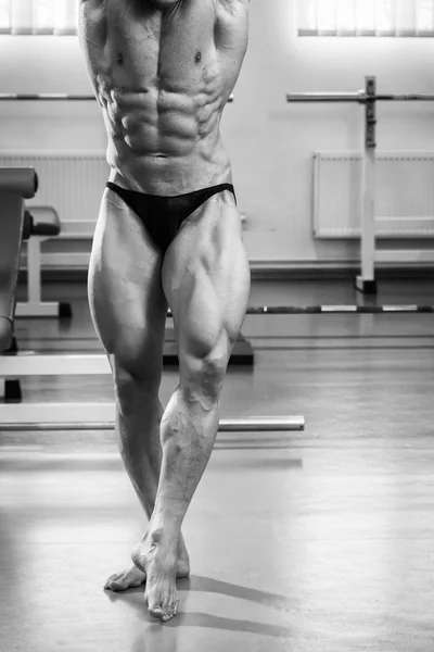 Culturista demostrando los músculos en el gimnasio — Foto de Stock