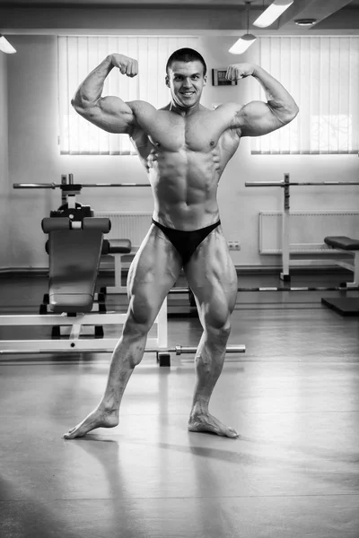 Fisiculturista demonstrando músculos no ginásio — Fotografia de Stock