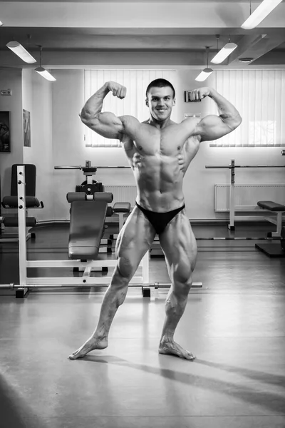Culturista demostrando los músculos en el gimnasio — Foto de Stock