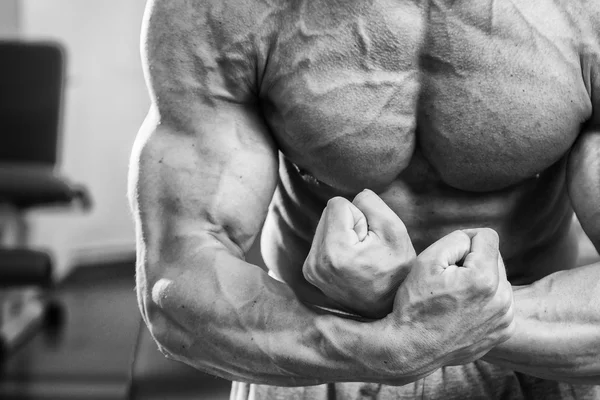 Culturista dimostrando muscoli in palestra — Foto Stock