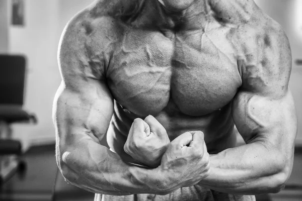 Culturista demostrando los músculos en el gimnasio — Foto de Stock