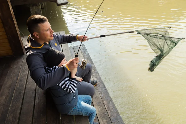 Padre e hijo en el proceso de captura de peces — Foto de Stock