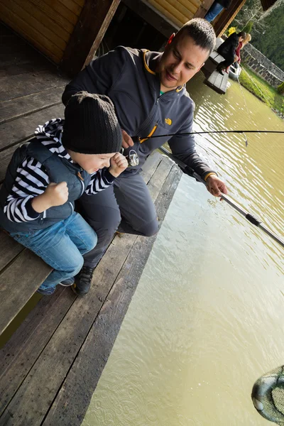 Padre e hijo en el proceso de captura de peces — Foto de Stock