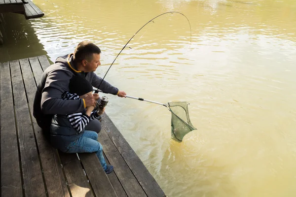 Padre e hijo en el proceso de captura de peces — Foto de Stock